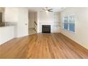 Spacious living room with hardwood floors, a cozy fireplace, and natural light from large windows at 2693 Avanti Way, Decatur, GA 30035