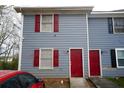 This charming townhome has blue siding, red shutters, and a bright red front door at 2726 Evans Mill Dr, Lithonia, GA 30058