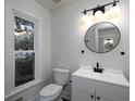 Modern half bath featuring updated fixtures, a sleek vanity, and natural light from a large window at 742 Olde Towne Ln, Marietta, GA 30068