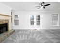 Bright living room with fireplace, plush carpet, and French doors leading to outdoor space at 742 Olde Towne Ln, Marietta, GA 30068