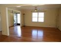 Open living room with hardwood floors, large windows, and ceiling fan at 575 Midland Park Dr, Stone Mountain, GA 30087