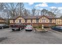 View of the home's exterior with Tudor-style details, parking spaces, mature trees, and landscaping at 3183 Abbeywood Dr, Decatur, GA 30034