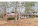 Attractive single-story home featuring brick accents, a covered carport, and mature trees at 50 Carriage Trce, Stockbridge, GA 30281