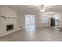 Open-concept living room featuring a brick fireplace, luxury vinyl plank flooring, and backyard access at 50 Carriage Trce, Stockbridge, GA 30281