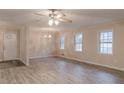 Bright living room with a modern ceiling fan, chandelier, and luxury vinyl plank flooring at 50 Carriage Trce, Stockbridge, GA 30281