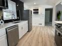 Modern kitchen with stainless steel appliances, white cabinets, and a black tiled backsplash at 3648 Garrison Sw Dr, Atlanta, GA 30331