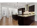 A modern kitchen with dark wood cabinets, granite countertops, and stainless steel appliances at 145 Rose Garden Ln, Alpharetta, GA 30009