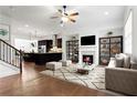 Open-concept living room with hardwood floors, fireplace, and view of the modern kitchen at 145 Rose Garden Ln, Alpharetta, GA 30009