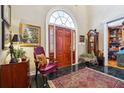 Elegant foyer with a red wood door, black tile flooring, and beautiful furnishings at 2595 Ross Rd, Snellville, GA 30039