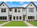 Charming new construction townhomes with white brick and siding, complemented by lush green lawns and professional landscaping at 1322 Parc Bench Rd, Atlanta, GA 30316