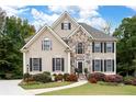 Inviting two-story home with stone accents, dark shutters, and a well-manicured lawn with a charming walkway at 4651 Oakleigh Manor Dr, Powder Springs, GA 30127