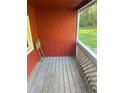 Red-painted porch with wood flooring and latticework railings at 482 Stallsworth Rd, Mcdonough, GA 30252