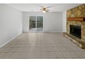 Bright living room with stone fireplace, ceiling fan, and sliding glass doors to the yard at 5808 Trent Walk Dr, Lithonia, GA 30038