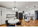 Bright eat-in kitchen featuring white cabinets, modern appliances, subway tile backsplash, and hardwood floors at 3180 Vine Cir, Decatur, GA 30033