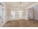 Bright dining area with wood floors, white trim, and a modern chandelier, perfect for Gathering dinners at 1521 Reids Ferry Way, Marietta, GA 30062