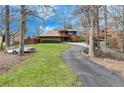 Beautiful wooded home with a large front yard, mature trees and a long driveway at 4110 Sinclair Shores Rd, Cumming, GA 30041