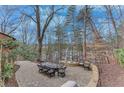 Paver patio featuring an outdoor dining table with seating for eight plus a stone fire pit at 4110 Sinclair Shores Rd, Cumming, GA 30041