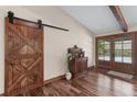 Foyer with a wood sliding barn door, stylish cabinet, and hardwood floors at 4230 N Elizabeth Se Ln, Atlanta, GA 30339