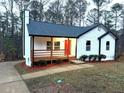 Charming single-story home featuring a cozy front porch and a vibrant red front door at 5729 Rock Rd, Union City, GA 30291