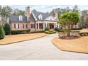 Beautiful home featuring a circular driveway, manicured lawn, and brick facade at 3201 Hobsons Ridge Nw Trl, Acworth, GA 30101