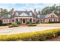 Elegant brick home featuring manicured landscaping and a circular driveway, exuding curb appeal at 3201 Hobsons Ridge Nw Trl, Acworth, GA 30101