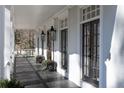 Inviting front porch with black painted wood floor, white columns, and lantern sconces at 4000 Conway Valley Nw Rd, Atlanta, GA 30327
