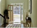Inviting foyer with an open wood front door, rug, and console table at 4188 Gunnerson Ln, Kennesaw, GA 30152