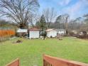 View of the spacious backyard featuring several storage sheds and mature trees at 6200 Josephine Rd, Atlanta, GA 30340