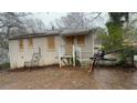 Back of home shows boarded-up windows, covered entrance and chain link fence at 1963 Oak Valley Rd, Decatur, GA 30035