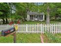 Home's front exterior showcasing well-manicured yard, white picket fence, and colorful landscaping at 1610 Elm Ne St, Conyers, GA 30012