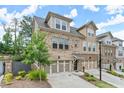 Attractive townhome exterior featuring brick and siding, an attached garage, and well-maintained landscaping at 2452 Coosa Vly, Atlanta, GA 30339