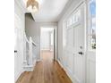 Bright hallway featuring hardwood floors, white trim, and a view to a window at 4590 Mountain Creek Ne Dr, Roswell, GA 30075