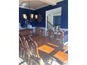 Elegant dining room with a large wooden table, chandelier, and dark blue accent wall at 3740 Tupelo Trl, Auburn, GA 30011