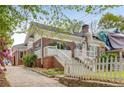 View of the house with brick facade, white trim and fence and stone retaining wall at 1626 Rogers Sw Ave, Atlanta, GA 30310