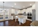 Bright kitchen features white cabinetry, stainless appliances, granite countertops and central island at 5255 Austrian Pine Ct, Cumming, GA 30040