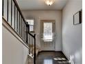 Inviting entryway with dark hardwood floors, staircase, and natural light from the front door at 1676 Charcoal Ives Rd, Lawrenceville, GA 30045