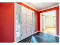 Bright foyer with a red accent wall, black slate floors and a white front door with side windows at 1958 Starfire Ne Dr, Atlanta, GA 30345