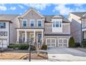 Traditional brick home featuring a two-car garage and welcoming front porch at 11330 Easthaven Pl, Johns Creek, GA 30097