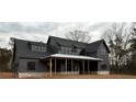 Newly built home with a combination of lap siding, metal roof accents, and expansive front porch at 157 Palisade Dr, Rydal, GA 30171