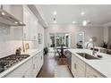 Modern kitchen with white cabinets, stainless steel appliances, and view to the open concept living room and outdoor patio at 642 Stickley Oak Way, Woodstock, GA 30189