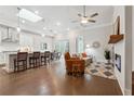 Bright open-concept living space with hardwood floors, modern fixtures, fireplace, and a kitchen with stainless steel appliances at 642 Stickley Oak Way, Woodstock, GA 30189