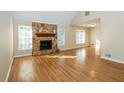 Bright living room with a stone fireplace, hardwood floors, and large windows at 241 The Esplanade Se Way, Loganville, GA 30052