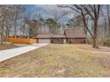 Ranch home with an attached garage and a long driveway surrounded by mature trees at 120 Arrowood Ln, Alpharetta, GA 30009