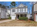 Traditional two-story home with a well-manicured front yard, attached garage, and covered front porch at 5545 Mountain Top Pl, Cumming, GA 30041