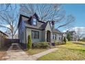 Side view of an updated two-story home with stone-grey brick, dormer windows and a side driveway at 1549 Beecher Sw St, Atlanta, GA 30310