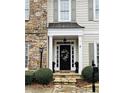 Inviting front door with decorative wreath, stone steps, and manicured landscaping at 1580 Reids Ferry Way, Marietta, GA 30062