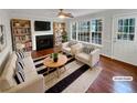 Bright living room featuring a fireplace, built-in bookshelves, and large windows at 1935 Wenton Pl, Lawrenceville, GA 30044