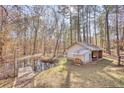 Scenic view of a pond with a small dock, surrounded by trees and a small shed with stacked wood at 2194 Highway 20 E., Mcdonough, GA 30252