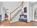 Inviting foyer with hardwood floors, staircase, and neutral wall paint at 5570 Saddle Tree Ct, Sugar Hill, GA 30518