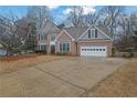 Charming two-story brick home with well-maintained lawn and a long driveway at 5570 Saddle Tree Ct, Sugar Hill, GA 30518